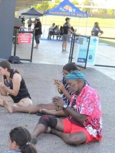 Group Sitting On Ground Weaving